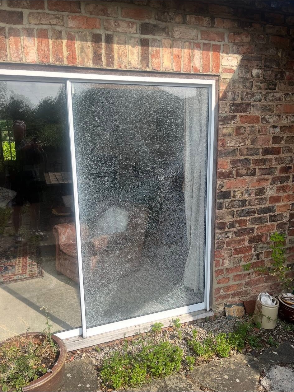 Sliding patio door with the glass panel smashed, before the repair